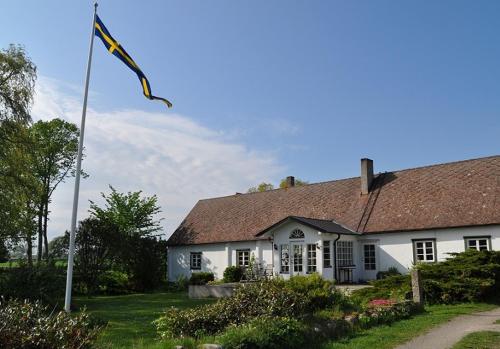 BromöllaRusthållaregården i Edenryd的前面有旗帜的白色房子
