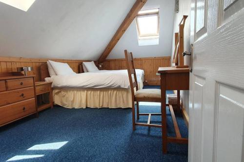 普里茅斯Stylish, comfortable apartment with balcony的一间卧室配有一张床、一张桌子和一把椅子