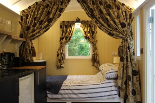 斯托马基特The Tawny Shepherd Hut, Whitehouse Farm的带床的客房,位于带窗户的厨房
