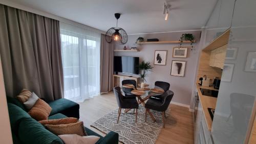 格但斯克Apartament Młody Gdańsk - bezpłatny parking, mocne WiFi, dobre połączenie z lotniskiem的客厅配有桌椅