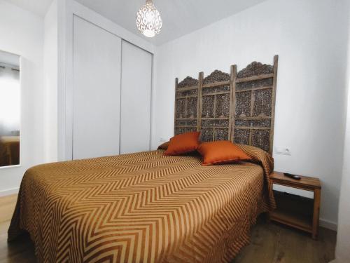马里亚诺Apartamento Santander Maliaño的一间卧室配有带橙色枕头的床