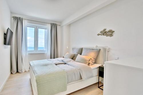 宁多夫Strandperle Ostsee Suite 1的白色的卧室设有床和窗户