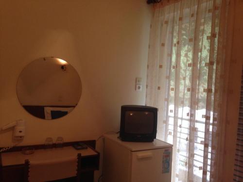 卡梅纳维洛拉Noufara Hotel的坐在一个房间梳妆台上的小电视