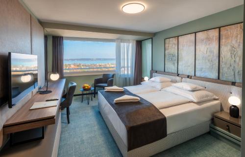 巴拉顿诺尔马迪汉格斯特巴尔度假酒店的酒店客房配有一张床、一张书桌和一台电视。