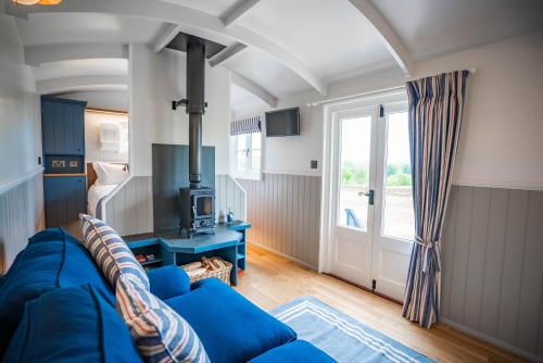 彭里斯Inglewood Shepherd's Huts的客厅设有蓝色的沙发和窗户。