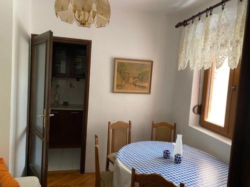 蒂瓦特Seljanovo 77m2的用餐室配有一张带蓝白格子桌布的桌子