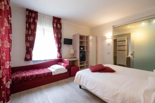 CadareseAlbergo Monte Giove的一间卧室配有一张床、一张沙发和一个窗口