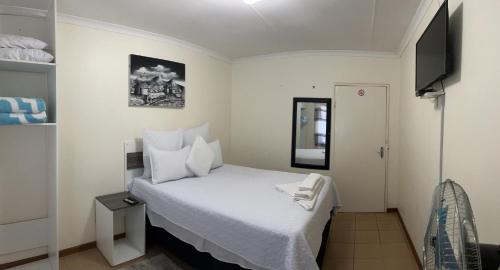 蓬戈拉Ncotshane BnB的一间小卧室,配有白色的床和电视