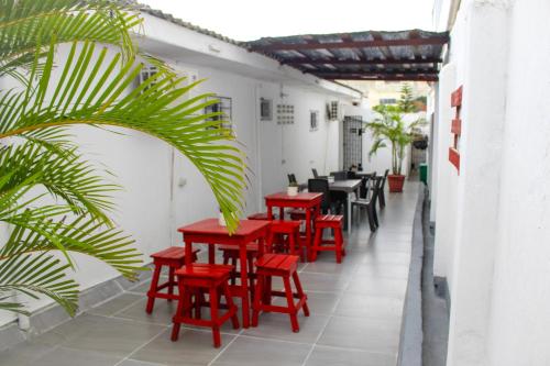 巴兰基亚Hotel Poblado Suite的庭院里一排红色的桌椅