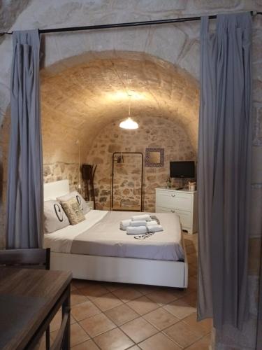 希克利Casa Loredana的卧室配有一张石墙内的大床