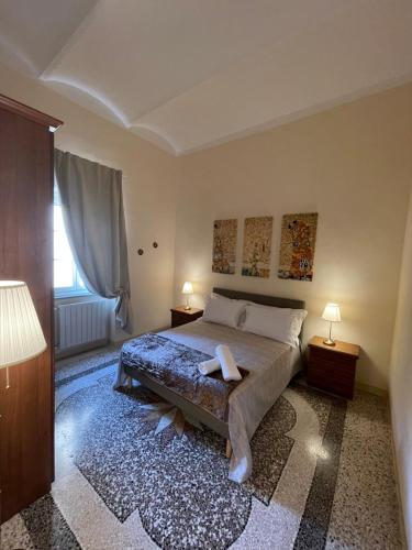 利沃诺Intero appartamento 3 letti con garage gratuito的一间卧室配有一张床、两盏灯和一个窗户。
