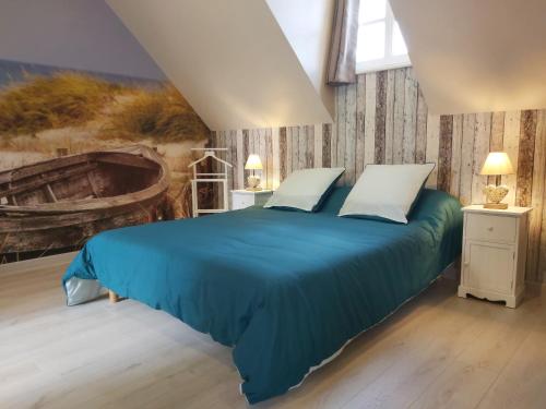 蒙特马丁恩格莱恩le bonheur des plumes的卧室配有一张蓝色的床,墙上挂着一幅画