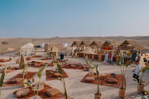 El KariaSelina Agafay Nomad Camp的沙漠中的一群帐篷和人
