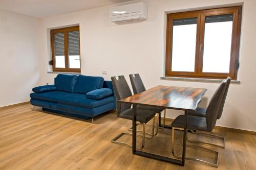ČrničeApartmaji Tanto Malovše的客厅配有桌子和蓝色沙发