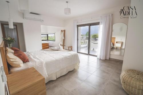 拉里奥哈Casa Adela - Cabañas Resort的一间白色卧室,配有床和阳台