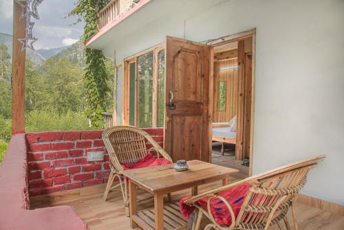 本贾尔Sharda Resort-Tirthan Valley的一个带桌椅和门的庭院