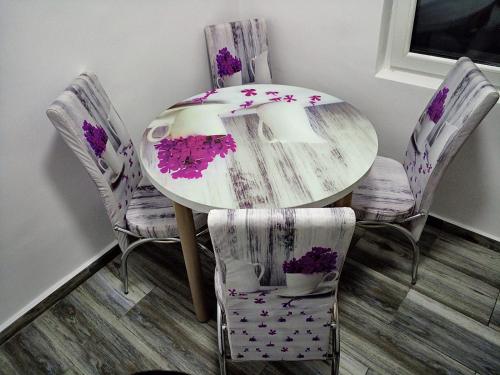 苏利纳Garsoniera Angelica的用餐室的桌子和椅子上布满了紫色的鲜花