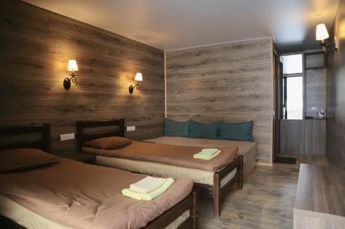 卡兹贝吉Kazbegi Cottages的木墙客房的两张床