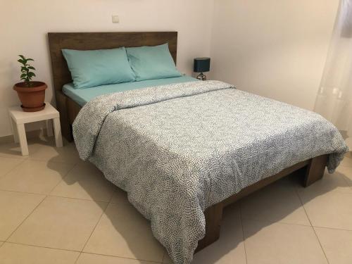 阿特米达Artemis House的一间卧室配有一张带蓝色棉被的床