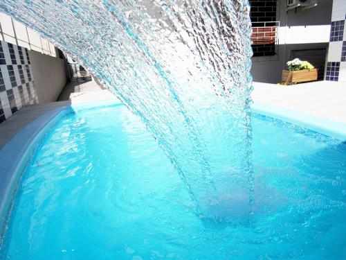 弗洛里亚诺波利斯POUSADA JURERE的游泳池中央的喷泉