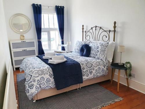 滨海索尔特本Coastal escape in the heart of Saltburn的一间卧室配有一张带蓝色和白色床单的床和窗户。