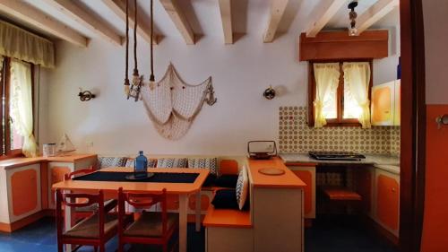杜纳维德Villa Lisa的厨房配有橙色橱柜和桌椅