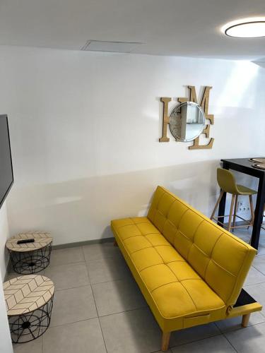 沙特尔Petite maison centre ville的一张黄色沙发,位于带桌子的房间
