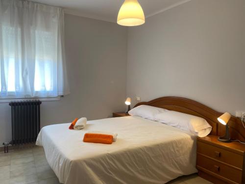 科利德纳尔戈Apartamento con estupendas vistas a Coll de Nargó的卧室配有白色的床,上面有橙色毛巾