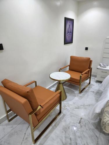 伊凯贾LUXOL HOMES&SUITES的客厅配有两把椅子和一张桌子