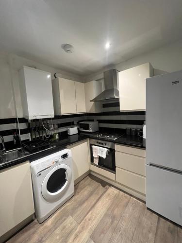 伦敦Lovely 3 Bedroom, Heart of London, Euston Kings cross st pancras的厨房配有洗衣机和冰箱。