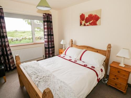 朗德斯通Roundstone Bay View的一间卧室设有一张大床和一个窗户。
