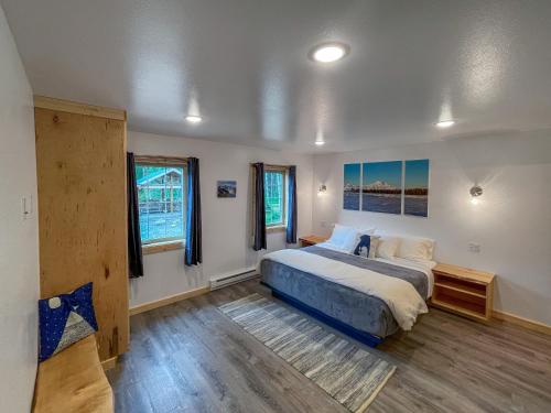 阳光城Talkeetna Wilderness Lodge & Cabin Rentals的一间卧室设有一张大床和两个窗户。