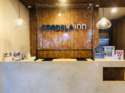 棉兰Cordela Inn Millennium Medan的带有阅读卡德利亚纳宾馆标志的柜台