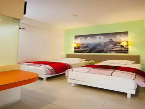 玛琅Dewarna Hotel Arifin的一间卧室设有两张床,墙上挂着一幅画
