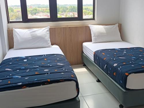 阿罗士打NZ Residence-Imperio Alor Setar 3BR Homestay Apartment的带2扇窗户的客房内的2张床