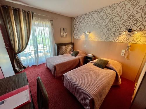 埃维昂莱班帕诺拉马酒店-餐厅的酒店客房设有两张床和窗户。