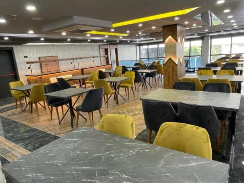 安塔利亚Grand Nergiz Otel的用餐室配有桌子和黄色椅子