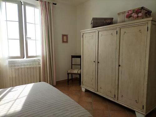 圣温琴佐Casaserena的一间卧室配有一张床和一个大型木制橱柜