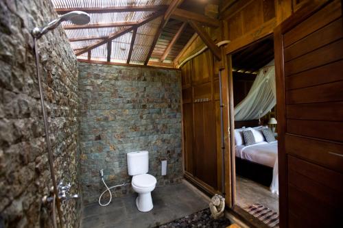德格拉朗Sebatu Tulen Villa的一间带卫生间的浴室,位于带一张床的客房内