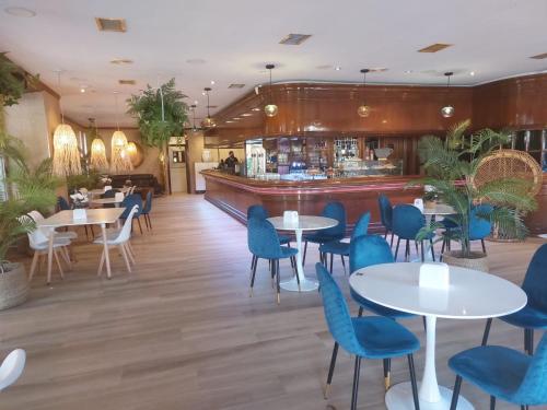列尔加内斯Hotel Cantabrico的一间带桌椅的餐厅和一间酒吧
