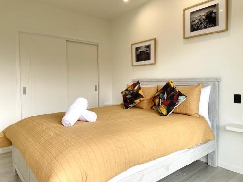 奥霍普海滩Ohope Villas with Spa,Sauna,Pool, Adults Only的一间卧室配有一张大床和枕头