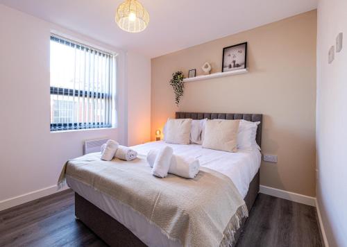 斯托克波特Stunning 1 bed apartment in the heart of Stockport的一间卧室配有一张大床和两个枕头