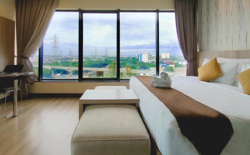 雅加达Vasaka Hotel Jakarta Managed by Dafam的一间酒店客房,设有一张大床和一个大窗户