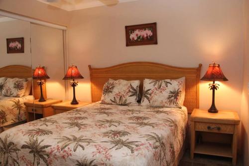怀卢库Maalaea Kai Resort 213的一间卧室配有一张床,两台桌子上放着两盏灯