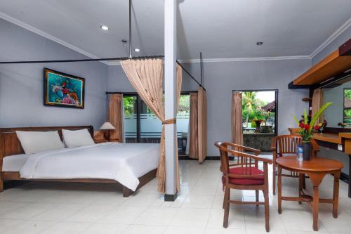 海神庙Dewi Sinta Hotel and Restaurant的卧室配有一张床和一张桌子及椅子