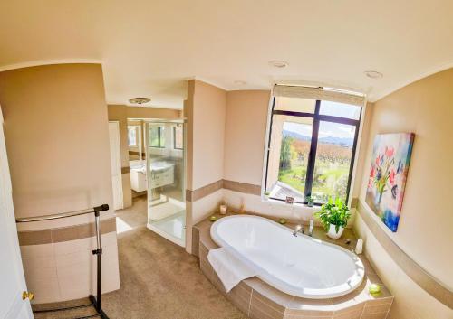 布伦海姆Fairhall Lodge的带浴缸和窗户的大浴室