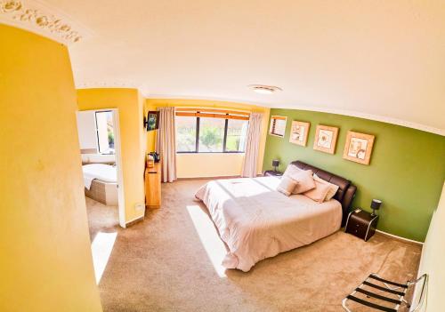 布伦海姆Fairhall Lodge的一间卧室设有一张床和绿色的墙壁