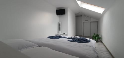 奥尔绍瓦Apartament La Sika的白色卧室配有一张大床,上面有蓝色的毛巾