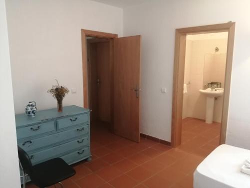 塔维拉Casa da Osga的一间带蓝色梳妆台的卧室和一间浴室