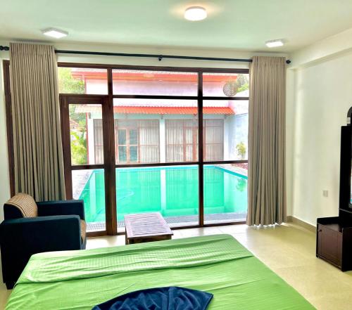 阿鲁甘湾Artist Village的一间卧室设有一张床,一个游泳池通过窗户